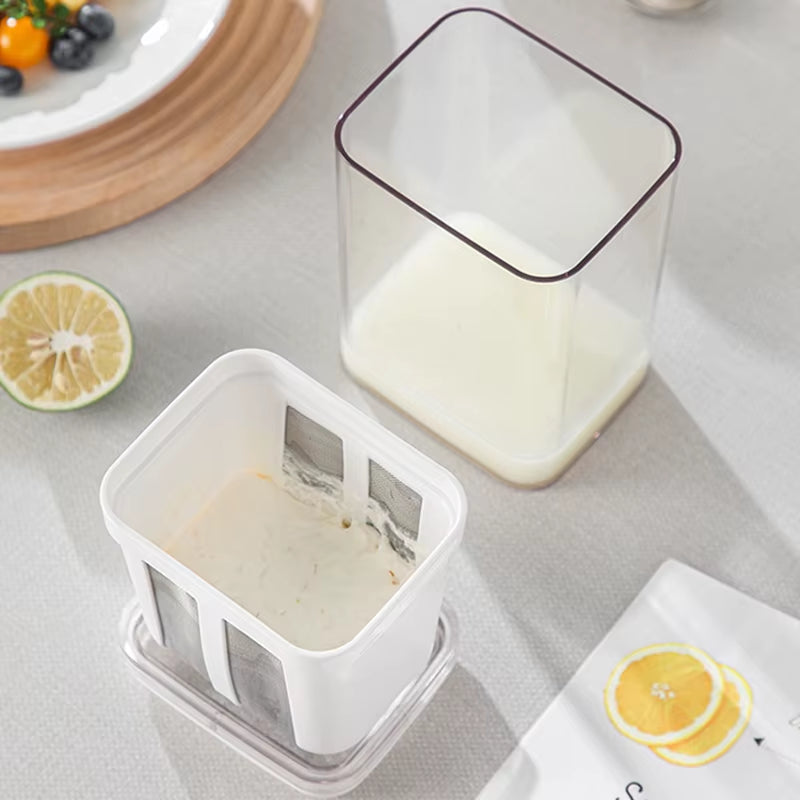Strainer basket with thick strained yogurt beside its clear outer container holding drained whey