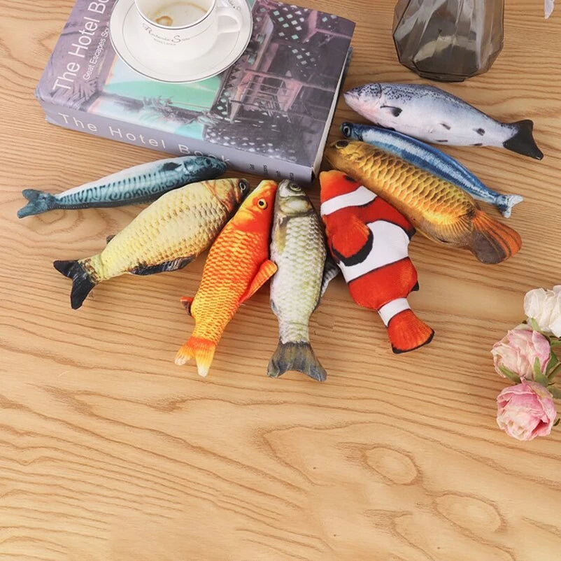 Assortment of realistic fish toys in salmon, mackerel, koi, goldfish, carp, and clownfish prints on a wood table with a book and roses