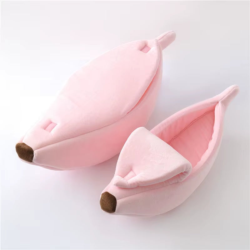Two pink banana-shaped cat beds, one closed and one open showing the interior lining, on white background