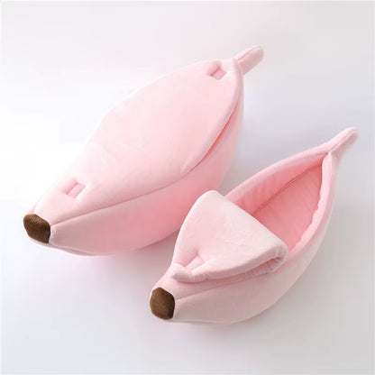 Two pink banana-shaped cat beds, one closed and one open showing the interior lining, on white background