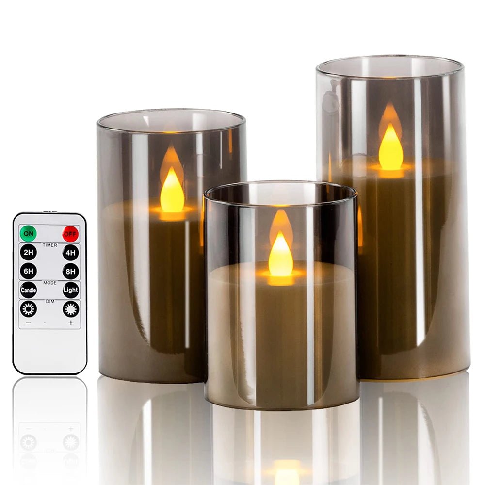 Three smoke-grey tinted glass LED candles with flickering flame and remote control, on white background