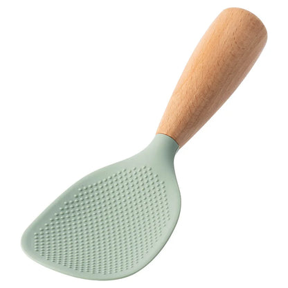 Sage green silicone rice paddle with beech wood handle, angled studio shot on white background