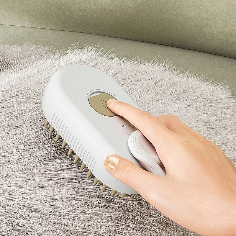 Close-up of a hand pressing the steam button on a grey brush while grooming grey pet fur on a couch
