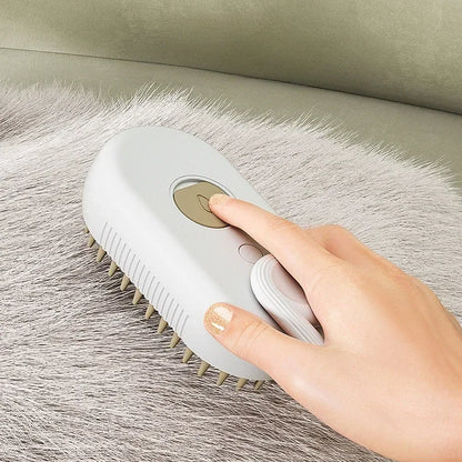 Close-up of a hand pressing the steam button on a grey brush while grooming grey pet fur on a couch