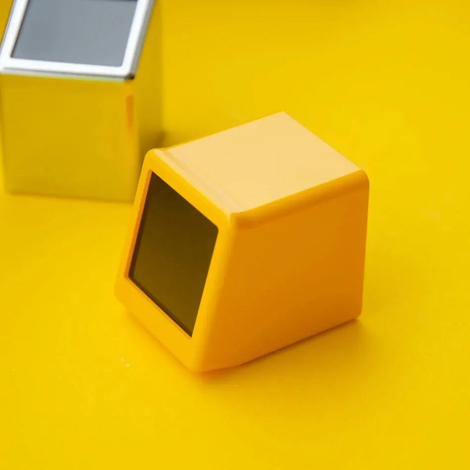 Top-rear angle of yellow weather clock with blank screen, silver unit visible in background