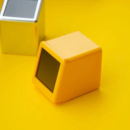 Top-rear angle of yellow weather clock with blank screen, silver unit visible in background