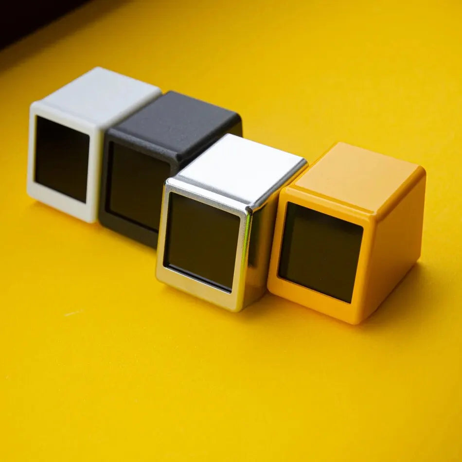 Four color options of the weather clock lined up: white, black, silver and yellow, screens off
