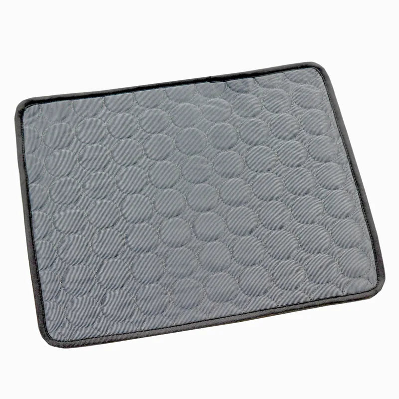 Dark grey quilted cooling gel mat with black trim, laid flat, angled studio shot on white background