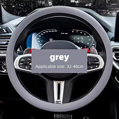 Grey silicone cover fitted on a steering wheel with a city skyline reflected in the windshield behind