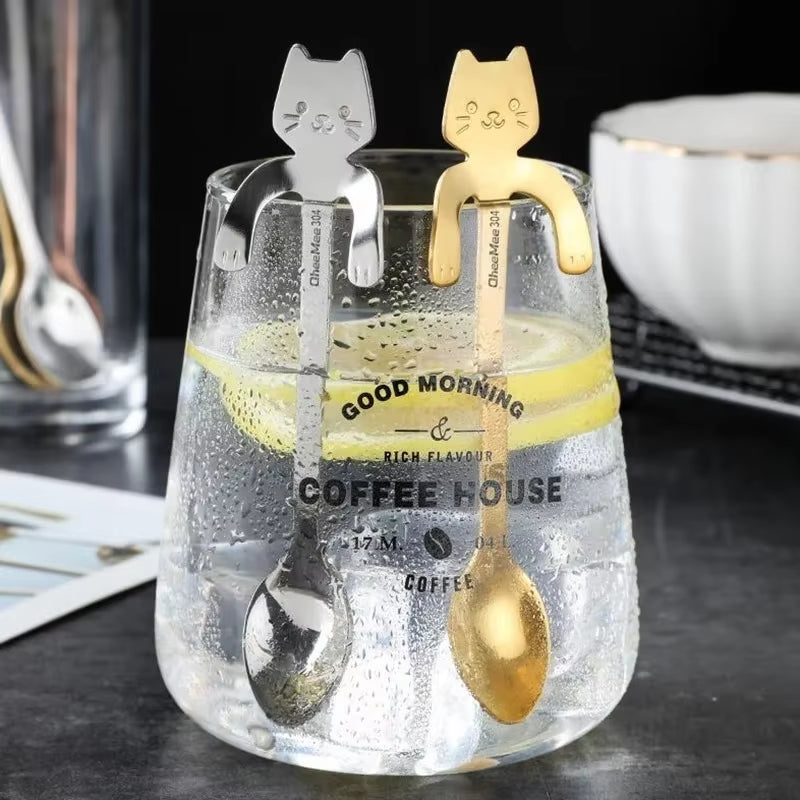 Silver and gold cat spoons hooked on glasses of iced coffee reading Good Morning Coffee House