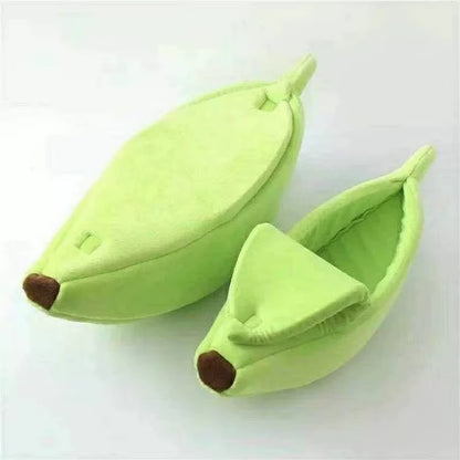 Two green banana-shaped cat beds, one closed and one open showing the interior lining, on white background