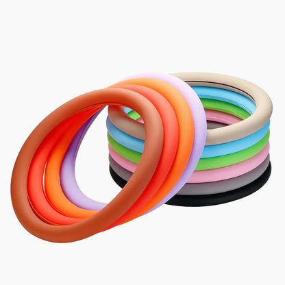 Several colored silicone steering wheel covers looped together showing orange, coral, lilac, tan, blue, green, and grey