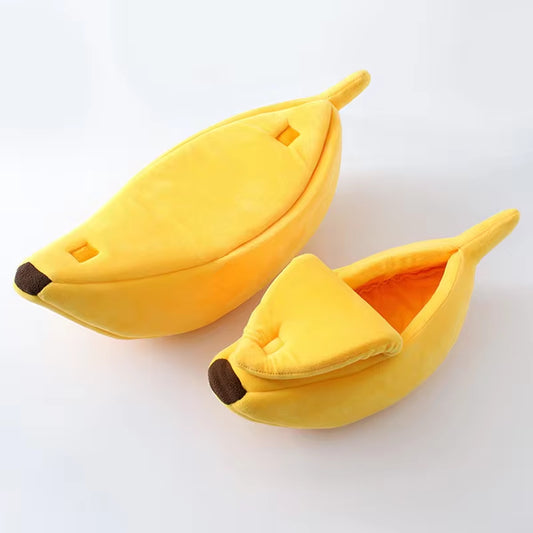 Two yellow banana-shaped cat beds, one closed and one open showing the orange interior lining, on white background