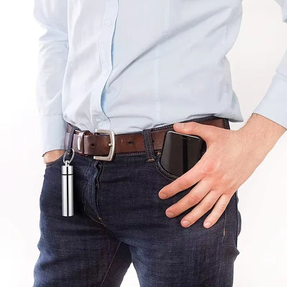 Man's belt loop with the toothpick case clipped on by its keyring, hand reaching into a jeans pocket