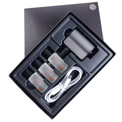 Overhead view of the open retail box showing the diffuser, three refill bottles, and charging cable in a tray