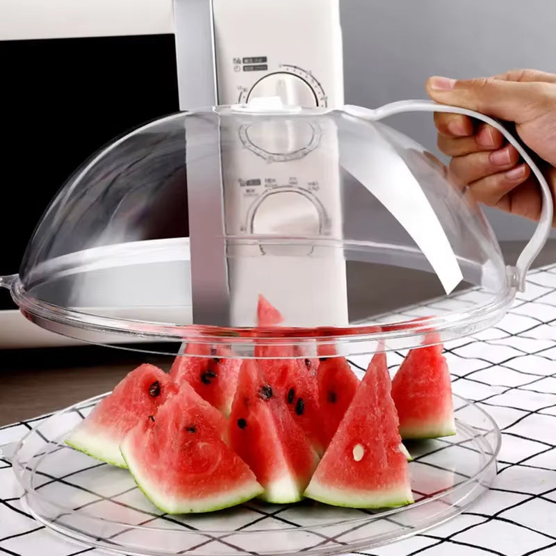 Hand lifting the clear dome cover off a tray of watermelon wedges on a checkered tablecloth